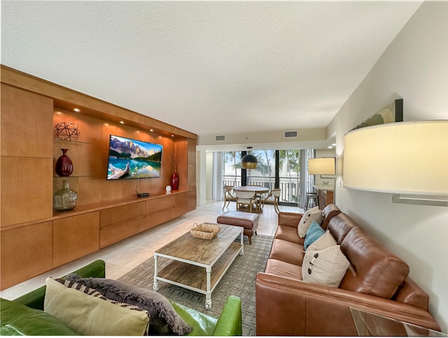 tiled living room featuring a textured ceiling