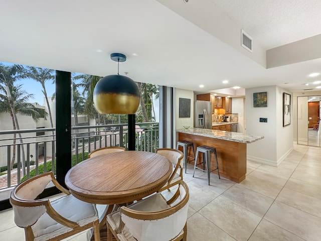 tiled dining space featuring a healthy amount of sunlight