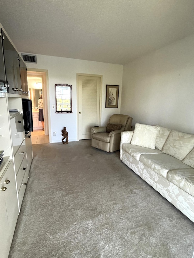 unfurnished living room featuring light carpet and a textured ceiling