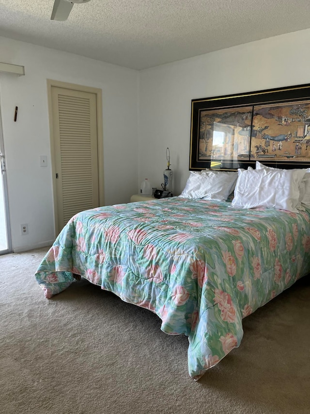 bedroom with carpet flooring, ceiling fan, and a textured ceiling