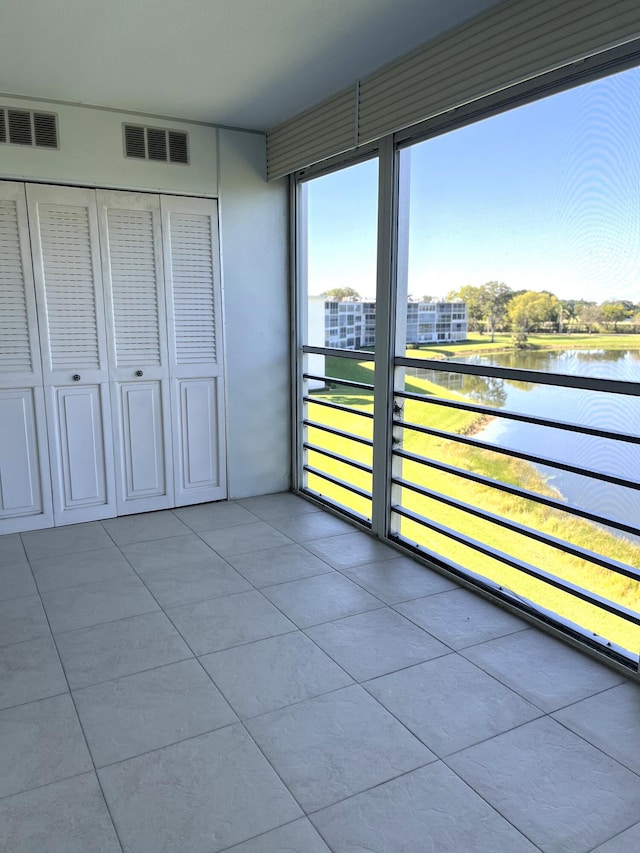 unfurnished sunroom featuring a water view