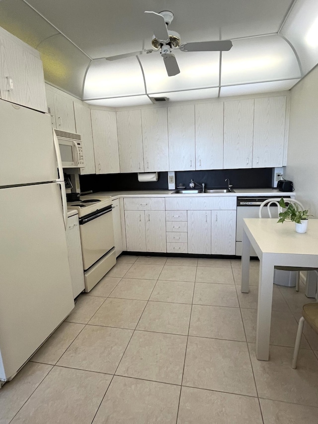 kitchen featuring white appliances, white cabinets, sink, ceiling fan, and light tile patterned flooring