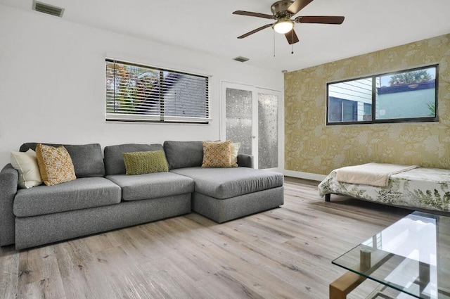 living room with light hardwood / wood-style flooring and ceiling fan