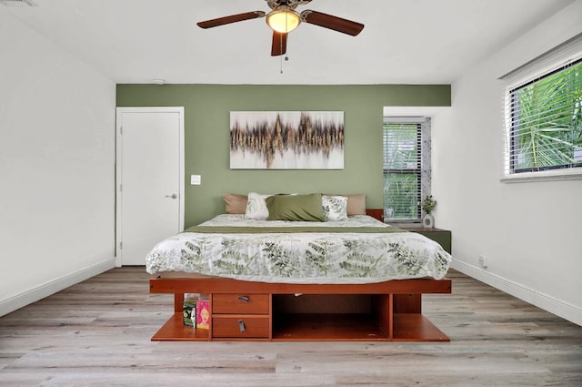 bedroom with light hardwood / wood-style floors and ceiling fan