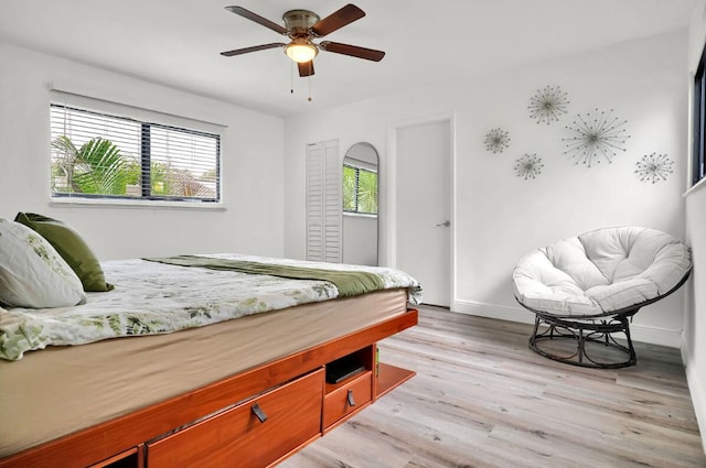 bedroom with light hardwood / wood-style floors, multiple windows, and ceiling fan