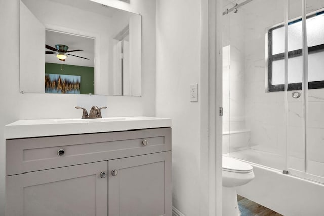 full bathroom with hardwood / wood-style floors, vanity, tiled shower / bath, ceiling fan, and toilet