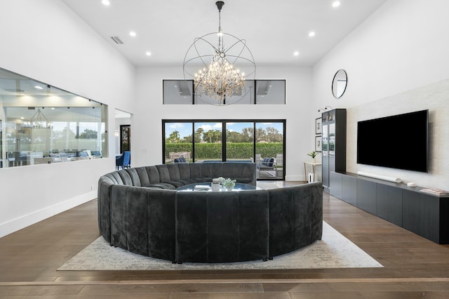 living room featuring dark hardwood / wood-style floors, a high ceiling, and a chandelier