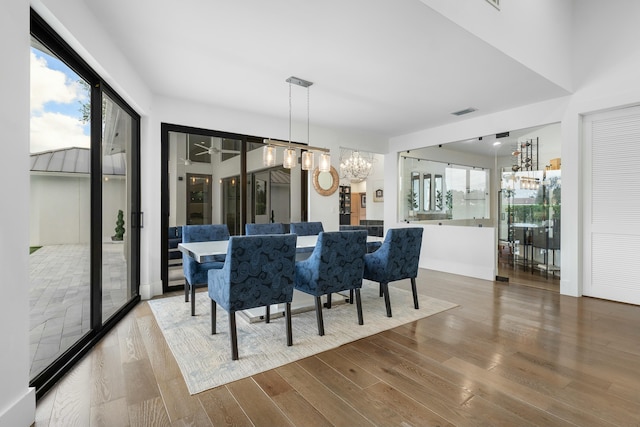 dining room featuring wood-type flooring and an inviting chandelier