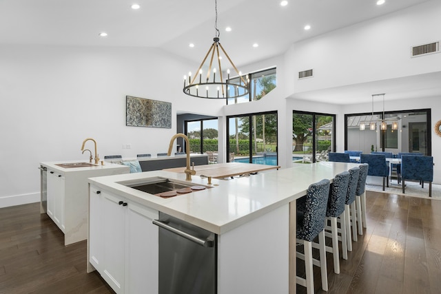 kitchen with white cabinets, dark wood-type flooring, plenty of natural light, and a spacious island