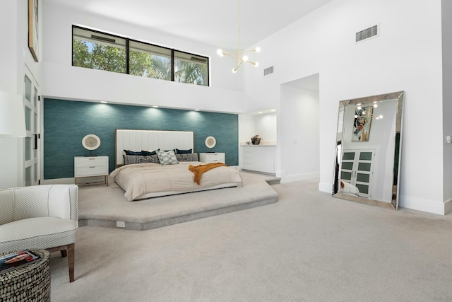 carpeted bedroom featuring a towering ceiling and a notable chandelier