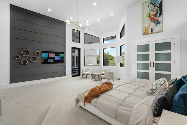 carpeted bedroom with a high ceiling and an inviting chandelier