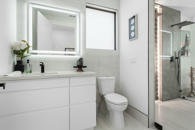 bathroom featuring a tile shower, vanity, and toilet