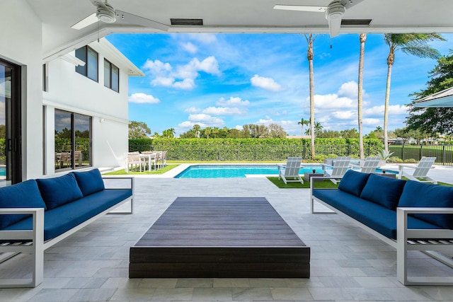 view of swimming pool featuring an outdoor living space, ceiling fan, and a patio