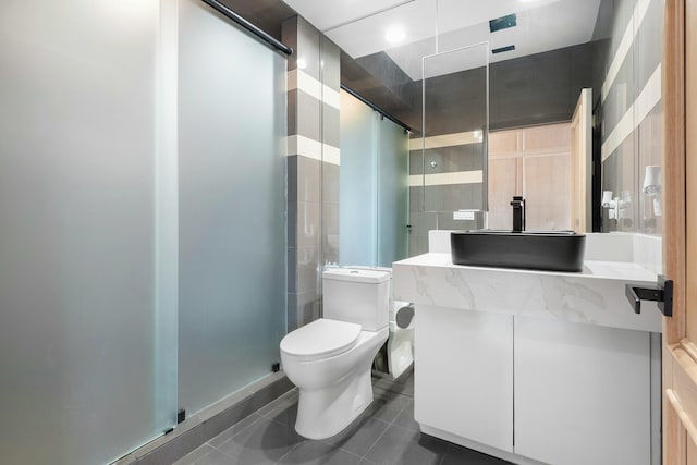 bathroom with tile patterned flooring, vanity, toilet, and a shower with shower door