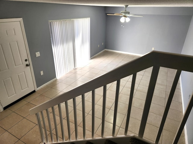 interior space featuring tile patterned floors, lofted ceiling, ceiling fan, and a textured ceiling