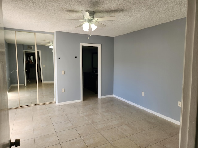 tiled spare room featuring ceiling fan and a textured ceiling