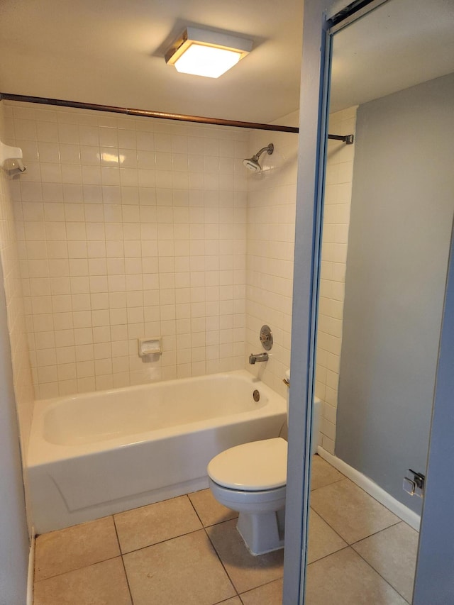 bathroom featuring tile patterned floors, toilet, and tiled shower / bath