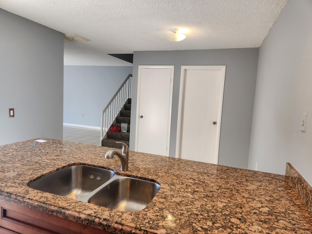 kitchen with sink, light tile patterned floors, and a textured ceiling