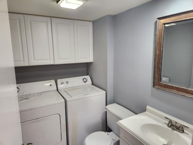 bathroom with toilet, sink, and washing machine and clothes dryer