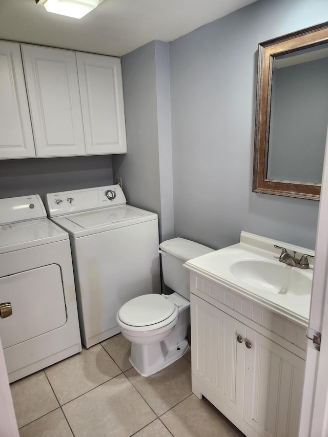 bathroom with washer and dryer, vanity, tile patterned flooring, and toilet