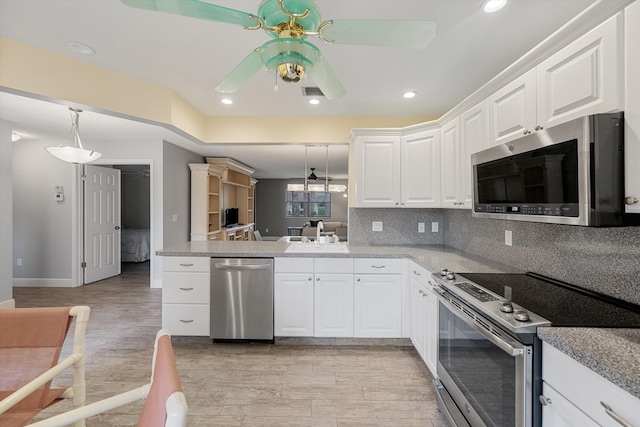 kitchen with white cabinets, decorative backsplash, stainless steel appliances, and light hardwood / wood-style flooring