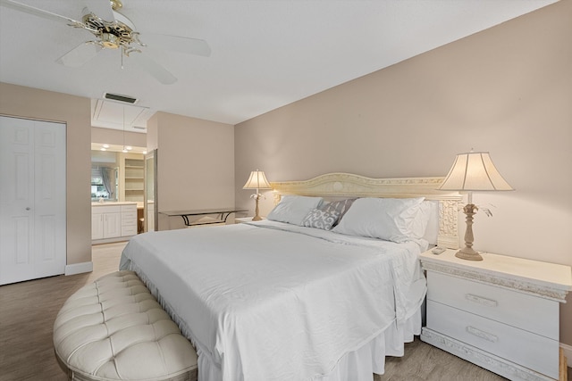 bedroom with connected bathroom, a closet, light hardwood / wood-style flooring, and ceiling fan