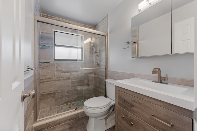 bathroom with vanity, an enclosed shower, and toilet