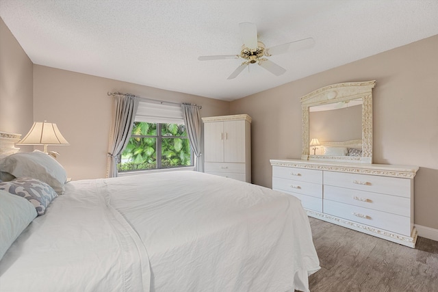 bedroom with ceiling fan, dark hardwood / wood-style floors, and a textured ceiling