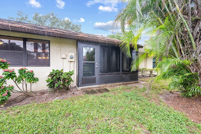 property entrance featuring a lawn