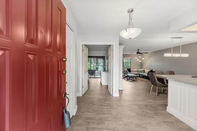 entrance foyer with ceiling fan, light hardwood / wood-style floors, and a textured ceiling