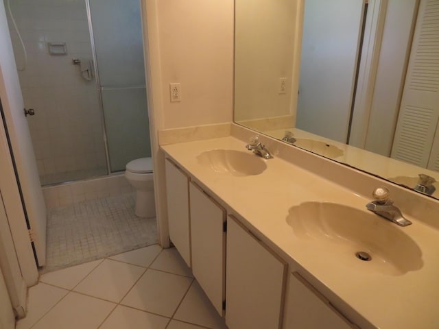 bathroom featuring an enclosed shower, vanity, tile patterned floors, and toilet