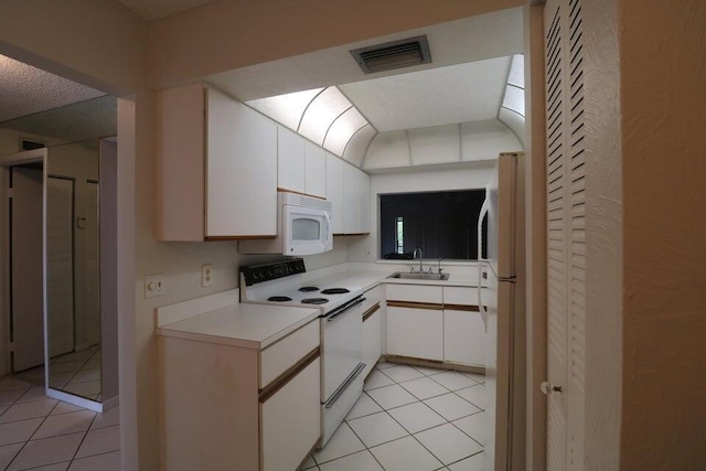 kitchen featuring light tile patterned flooring, white appliances, sink, and white cabinets