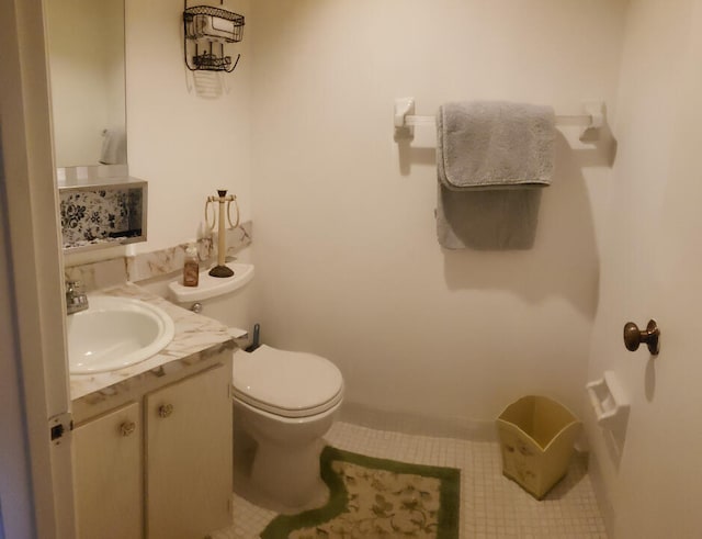 bathroom with tile patterned flooring, vanity, and toilet