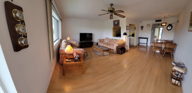 living room featuring a wealth of natural light, ceiling fan, and hardwood / wood-style flooring