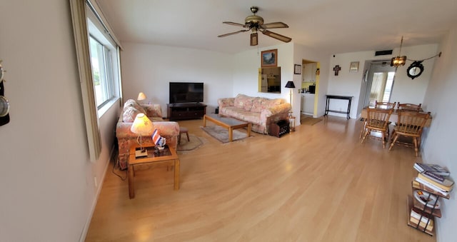 living room featuring light wood-type flooring and ceiling fan