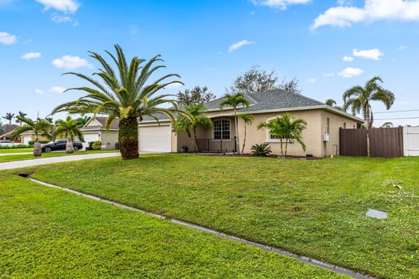 ranch-style house featuring a garage and a front lawn