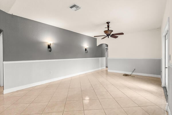 tiled empty room featuring ceiling fan and lofted ceiling