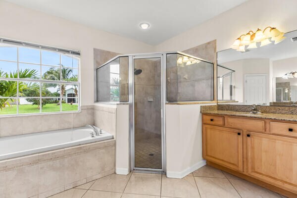 bathroom with shower with separate bathtub, vanity, and tile patterned floors