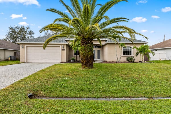 view of front of home with a front yard and a garage