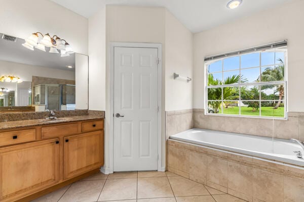 bathroom with tile patterned flooring, vanity, and independent shower and bath