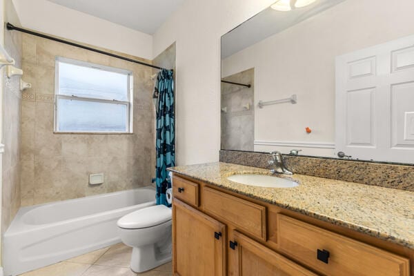 full bathroom with tile patterned floors, vanity, toilet, and shower / bath combo with shower curtain