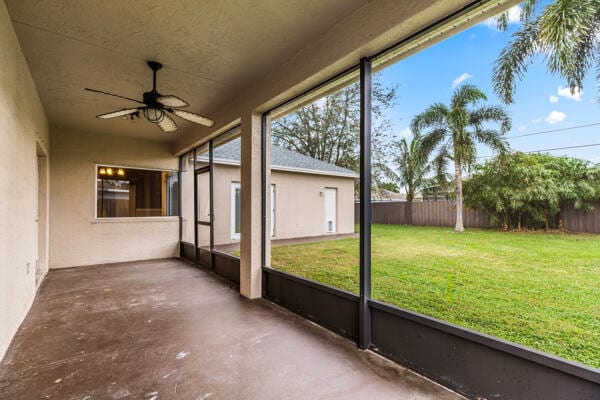 unfurnished sunroom featuring ceiling fan