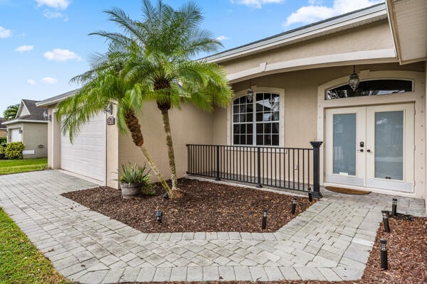 view of exterior entry with french doors and a garage