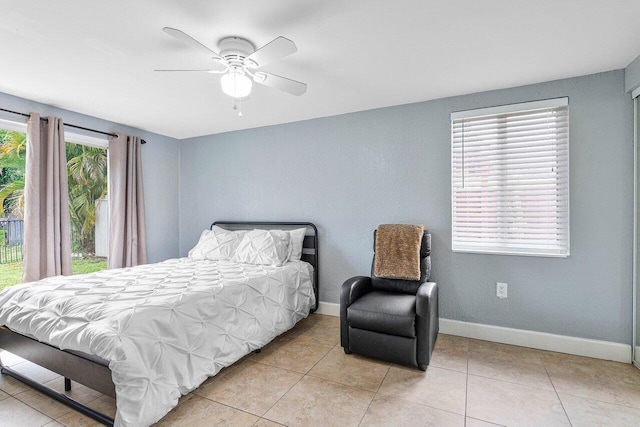 bedroom featuring ceiling fan, light tile patterned floors, and multiple windows