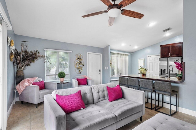 living room with ceiling fan, lofted ceiling, and sink