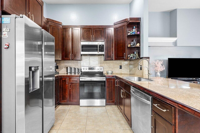 kitchen featuring backsplash, sink, light tile patterned floors, light stone counters, and stainless steel appliances