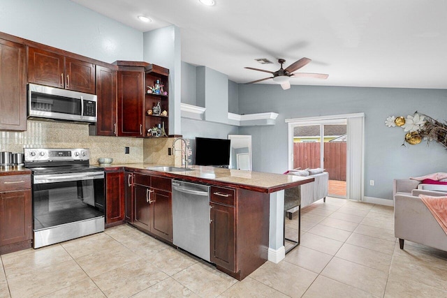 kitchen with sink, ceiling fan, appliances with stainless steel finishes, tasteful backsplash, and kitchen peninsula