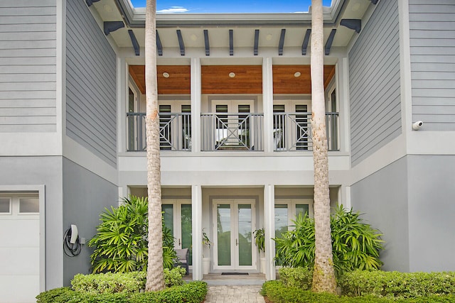 property entrance featuring a balcony and french doors