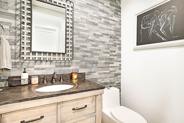 bathroom featuring decorative backsplash, toilet, and vanity