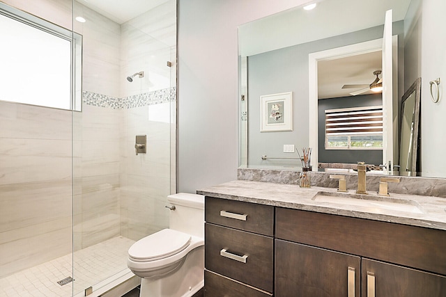 bathroom featuring walk in shower, vanity, toilet, and ceiling fan